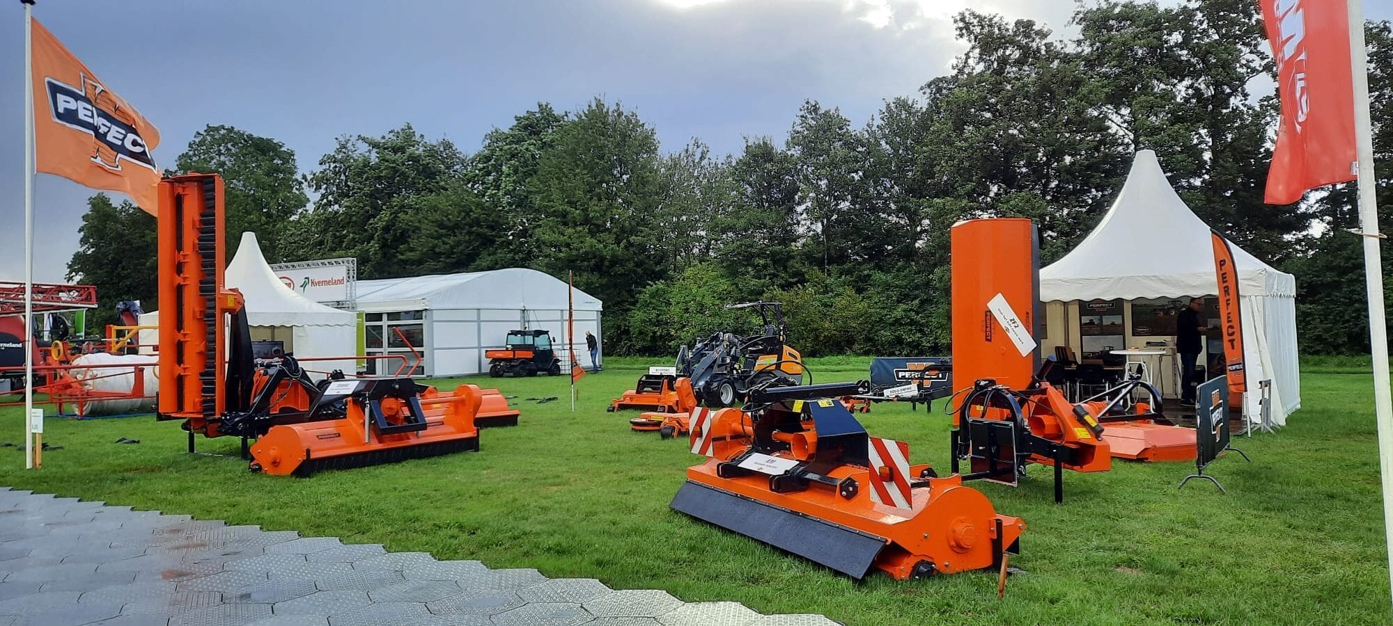 De beursstand van PERFECT – Van Wamel met oranje maaimachines op het gras