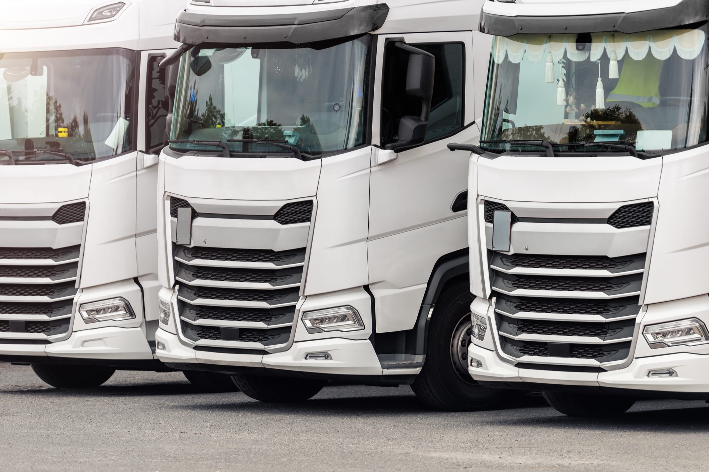 De voorkant van drie witte trucks met de voorruiten waarop de windshield-tags komen