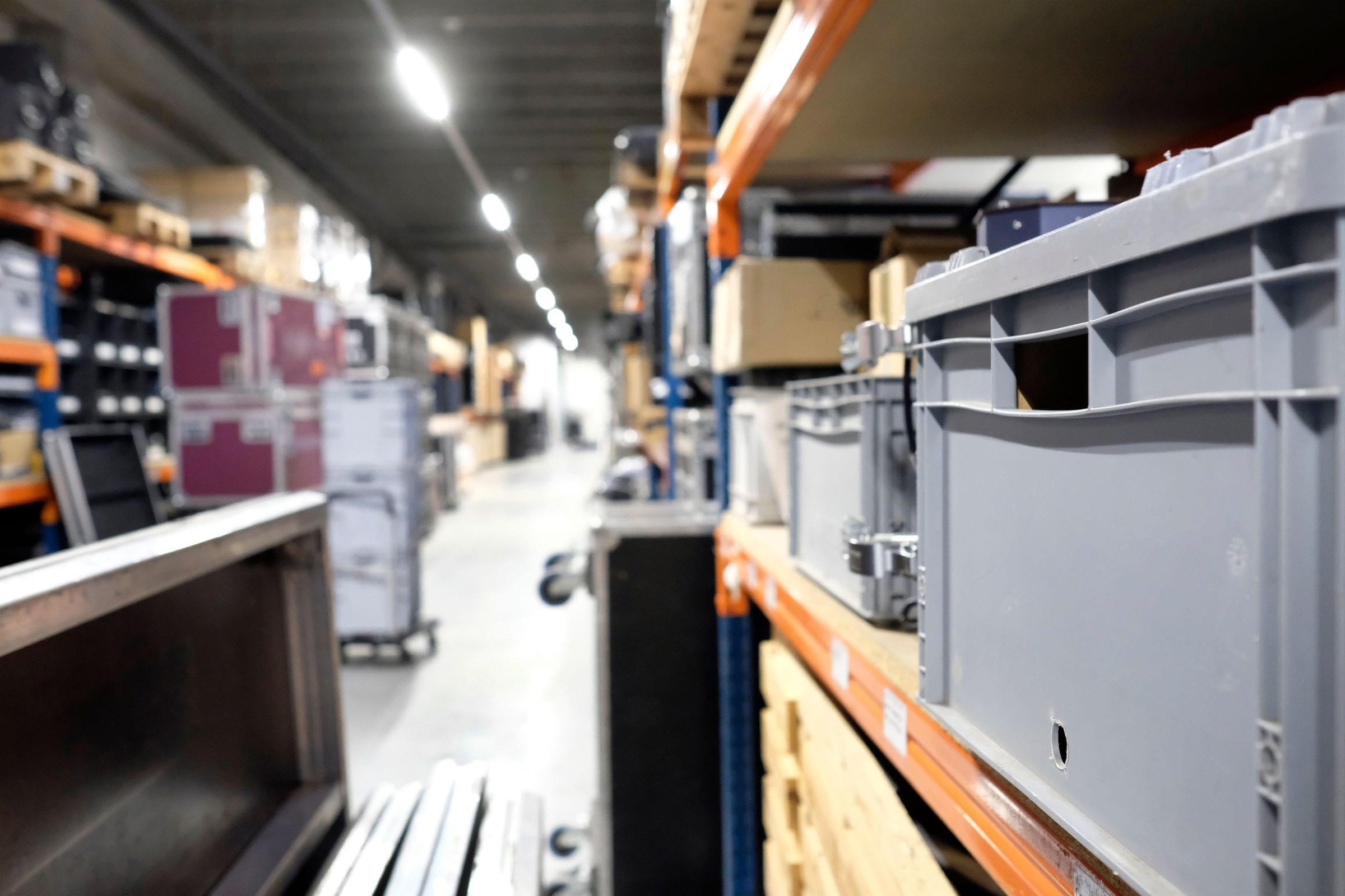 Een verhuurmagazijn met flightcases, kratten en stellingen